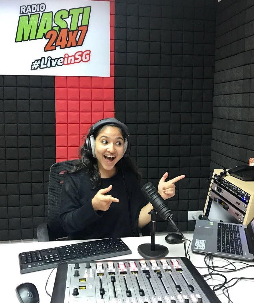 Gauraangi speaking into a microphone in a radio studio